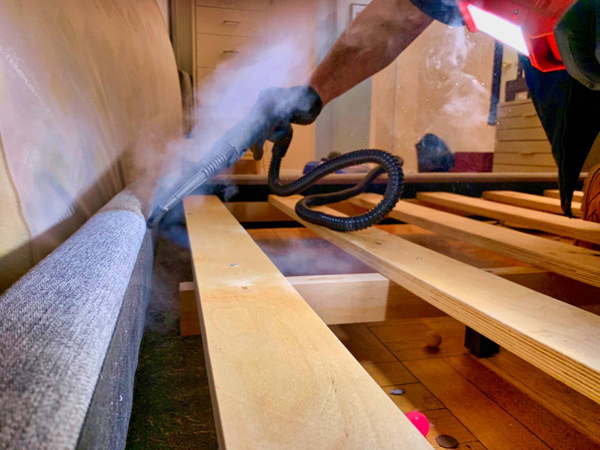 technician steaming mattress to kill bed bugs