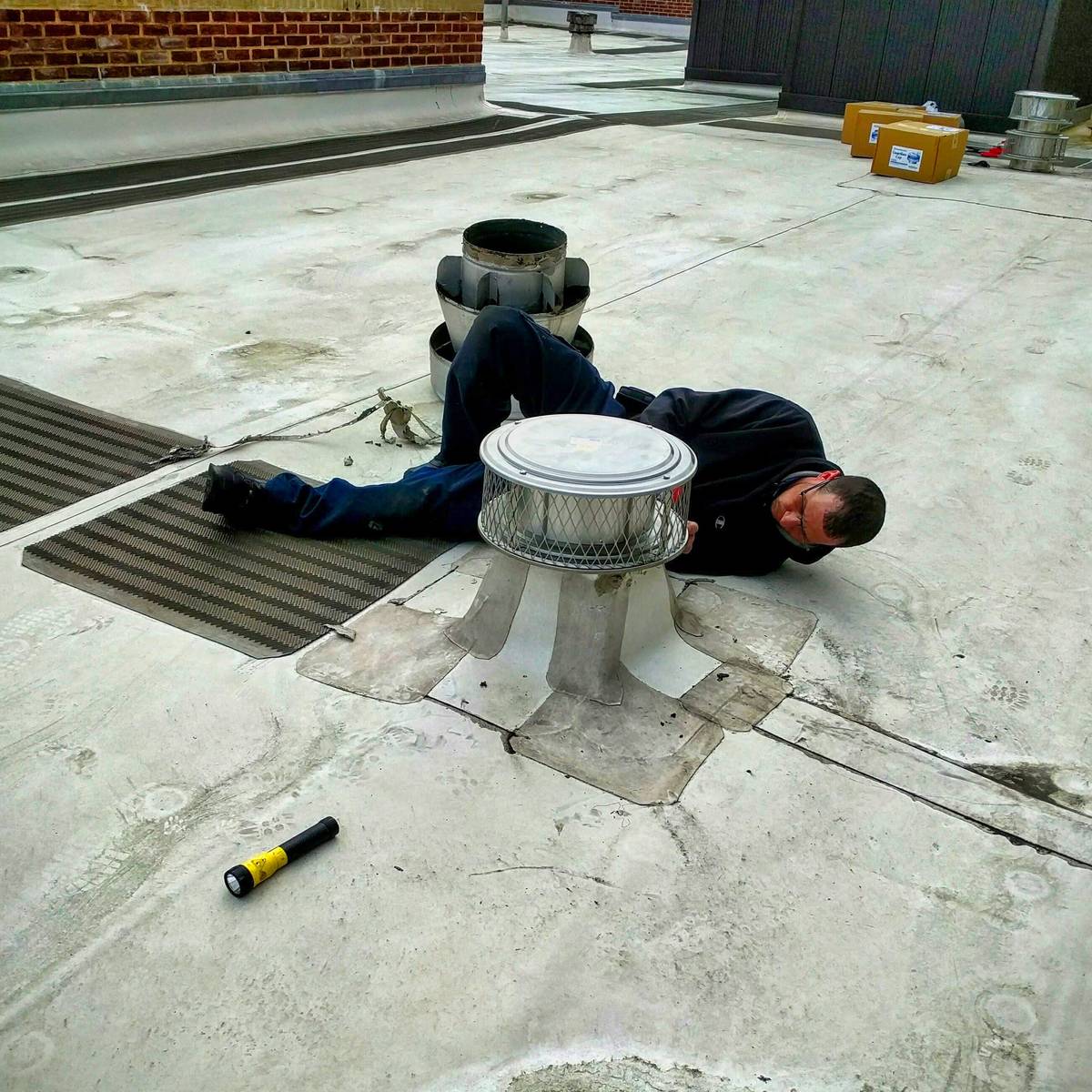 Rodent proofing technician sealing off a rooftop exhaust fan for biz in NYC